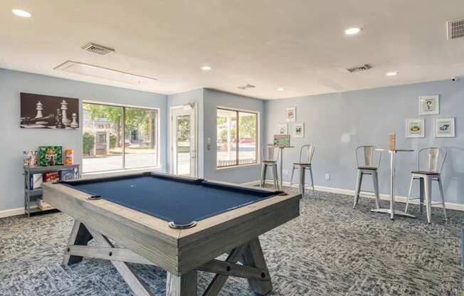 A pool table is in the middle of a room with a blue carpet.