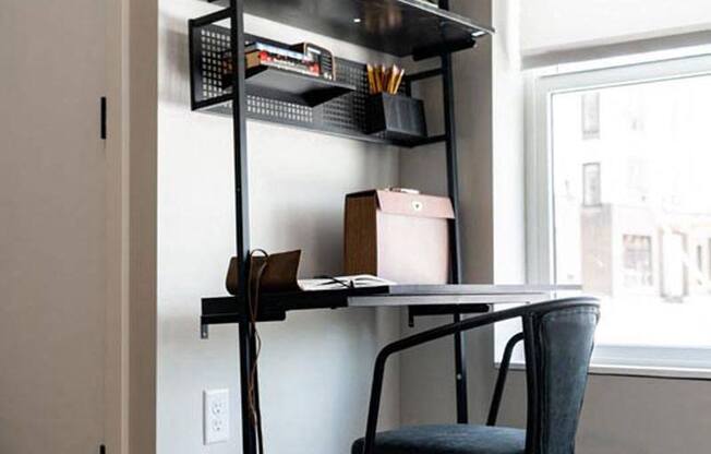 a desk with a chair and a shelf on a wall