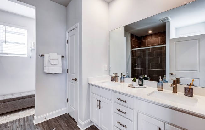 Designer bathrooms with double vanities, quartz countertops and large mirrors.