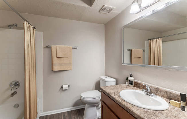 A bathroom with a toilet, sink, and shower.