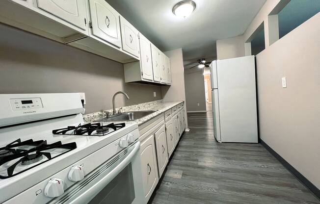 a kitchen with white appliances and white cabinets and a white refrigerator