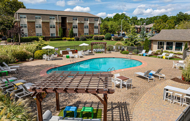 Drone shot of pool area with pavilion, seating and gas grills