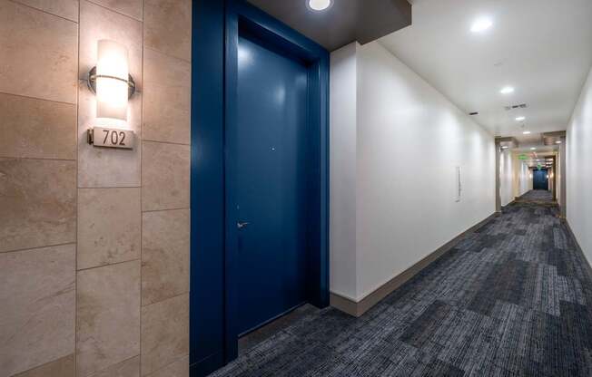 A hallway with a blue door and a sign that says N 702.