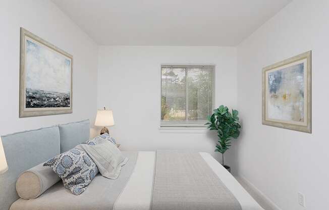 a bedroom with a bed and paintings on the wall