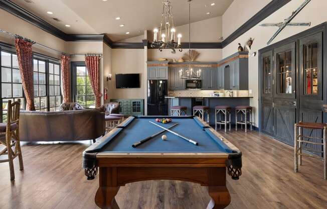 a game room with a pool table and a bar