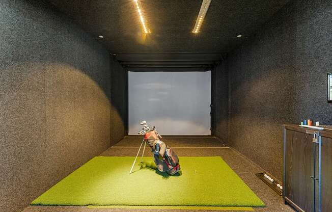 A person sitting on a green mat in a room with concrete walls.
