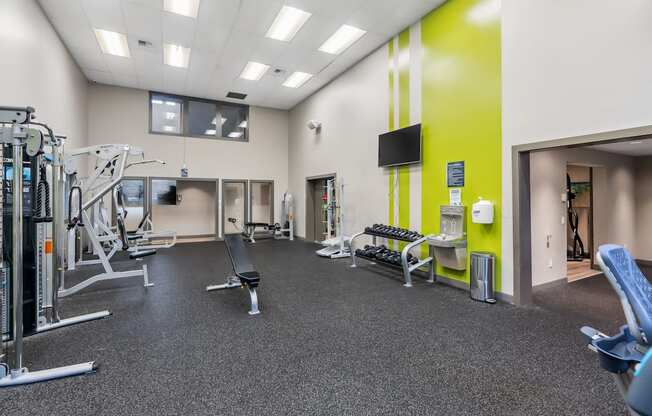 A gym with a variety of equipment including weights and machines.