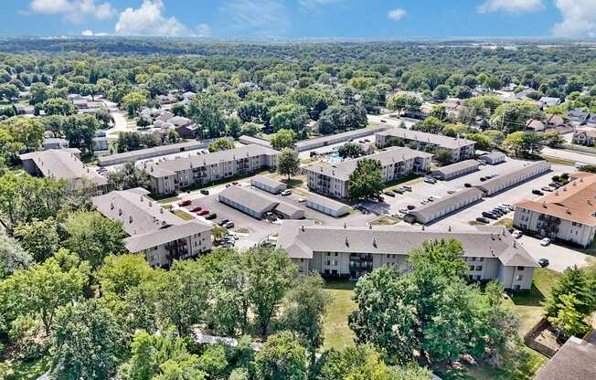 A bird's eye view of a residential complex surrounded by trees.