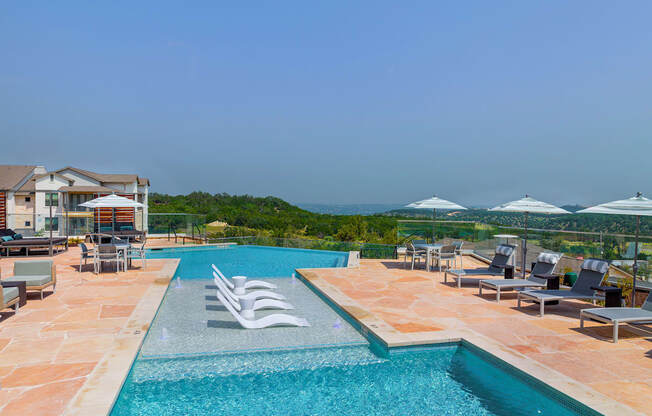 a swimming pool with chairs and umbrellas at a resort