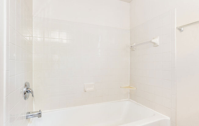 a white bath tub sitting next to a shower