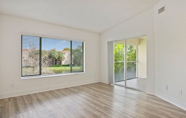 an empty living room with a sliding glass door to a patio