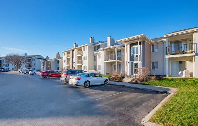 a row of apartment buildings with cars parked in front of them