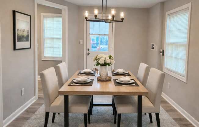 A dining room with a table set for six.