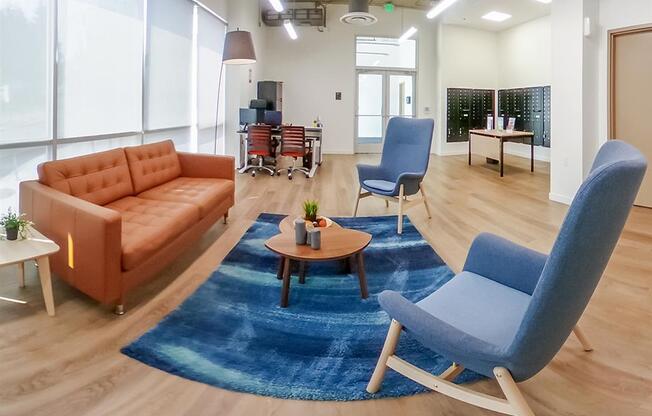 a living room with blue chairs and a brown couch at Jefferson Yards, Washington, 98402