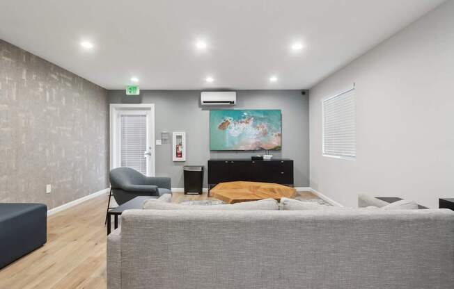 A bedroom with a bed, chair, and painting on the wall.