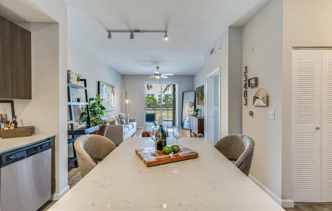 an open kitchen and living room area with a large white counter top