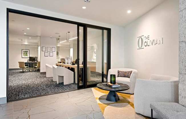 A modern living room with a glass door leading to a dining area.