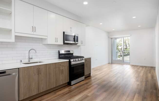 a white kitchen with wooden floors and white cabinets