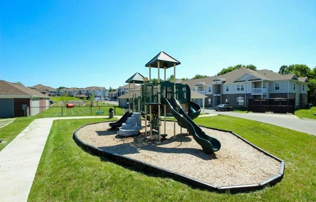 a playground with slides in a neighborhood with houses