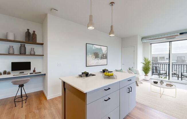 a kitchen with an island and a living room with a balcony