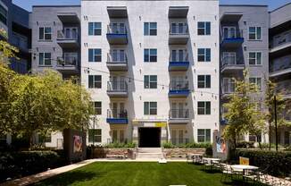 an exterior view of an apartment building with a lawn