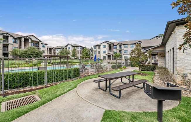 A picnic table sits in the middle of a concrete courtyard.