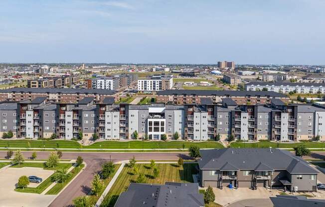 A large apartment complex with a parking lot in front.