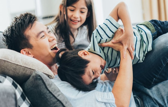 a man and a woman are sitting on a couch with a young boy and girl