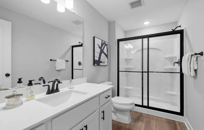 a white bathroom with a shower and a sink and a toilet