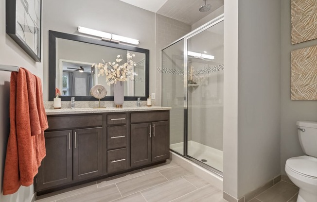 a bathroom with a shower and a sink and a mirror at Barclay Chase Apartment Homes, Marlton