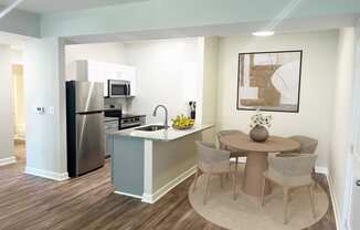 a kitchen and dining area with a stainless steel refrigerator