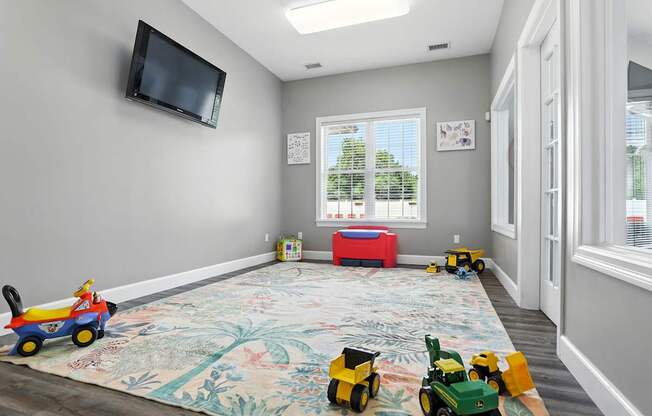 A room with a television, toys, and a table.