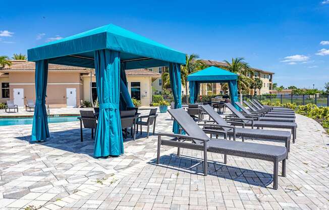 A poolside area with lounge chairs and a canopy.