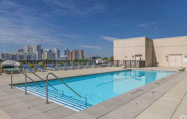 a pool on the roof of a building with a city in the background