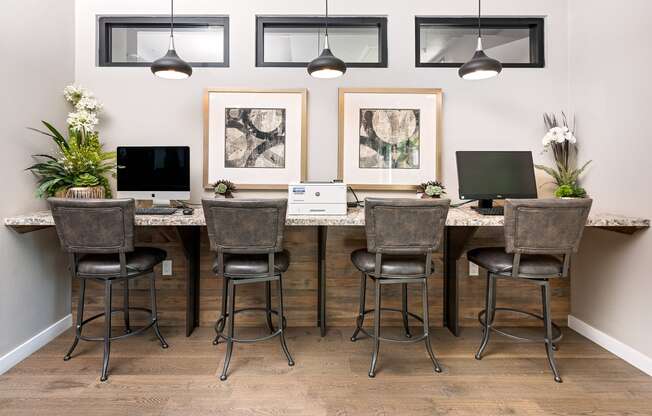 an office with a long desk with two computers on top of it