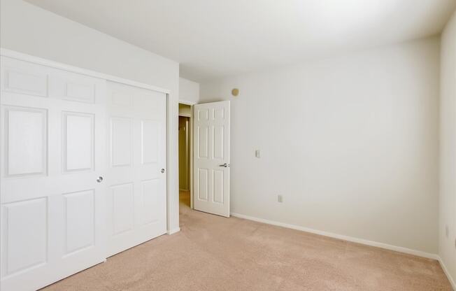 A room with a white door and carpeted floor.