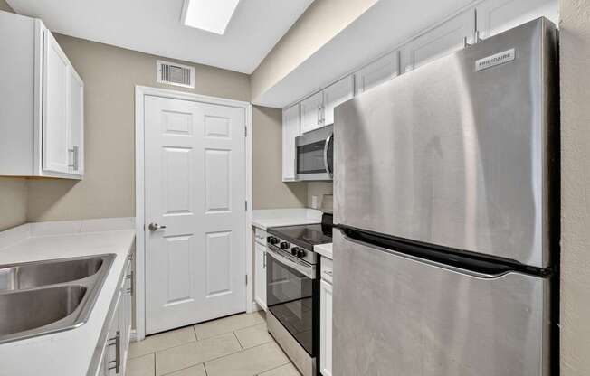 A kitchen with a stainless steel refrigerator, oven, and microwave.