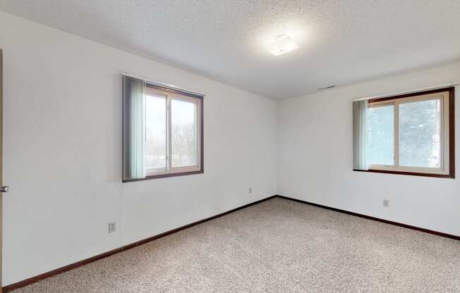 the living room of an empty house with two windows