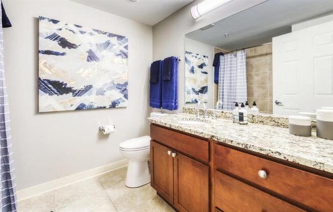 A bathroom with a toilet, sink, and a painting on the wall.