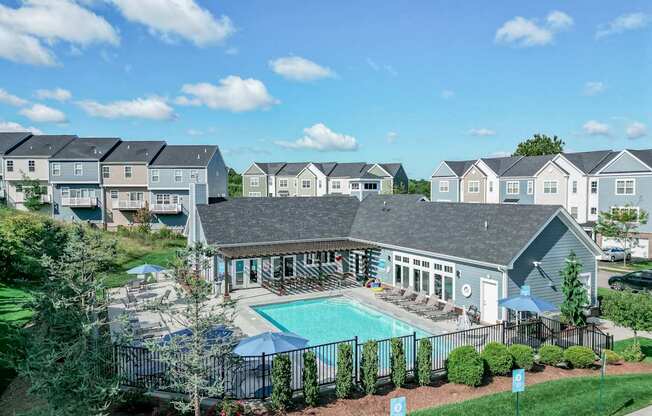 A swimming pool is surrounded by a fence and bushes.