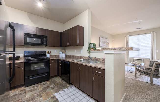 A kitchen with brown cabinets and a black stove top oven.