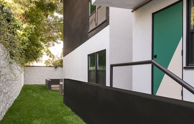 A white and black building with a green door.