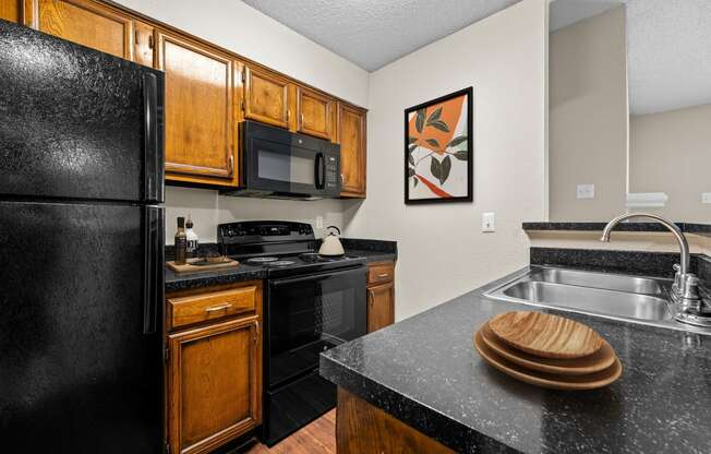 a kitchen with wooden cabinets and black appliances