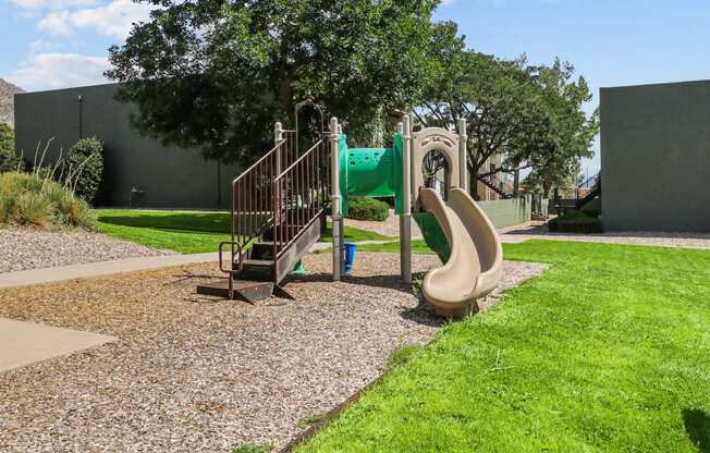 a playground with a slide and climbing equipment in a park