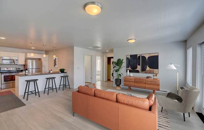 A modern living room with a bar area and a kitchen in the background.