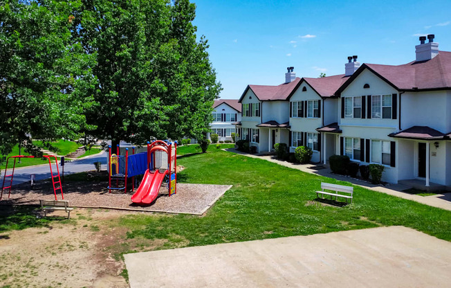 a playground in a park in front of some houses