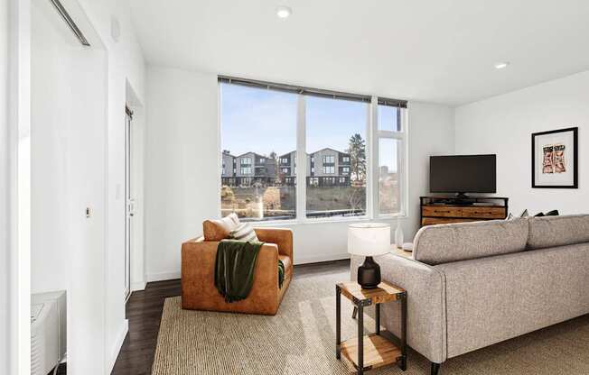 A living room with a couch, a chair, and a television.