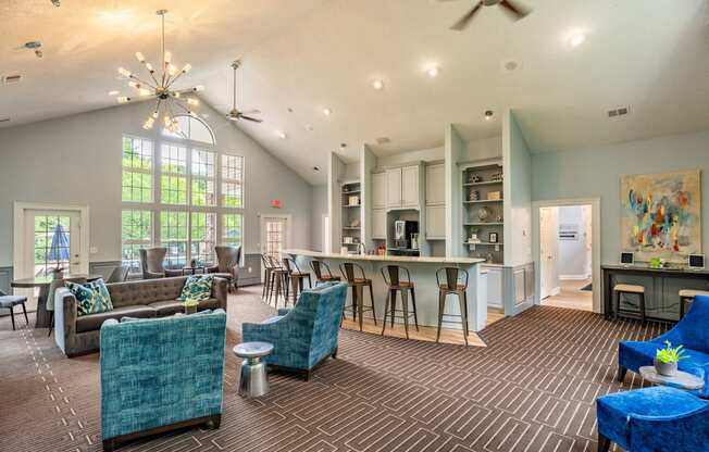 a spacious living room with couches and chairs and a kitchen with a breakfast bar