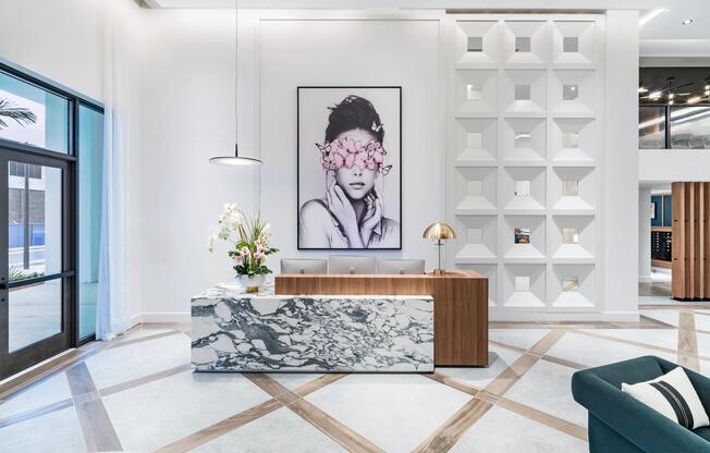 A sculptural arrival moment at Modera Aventura, pairing marble, warm wood, and curated art for a striking first impression rooted in coastal sophistication.