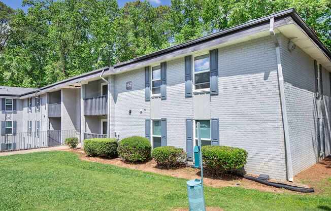Apartment building with green bushes in front.
